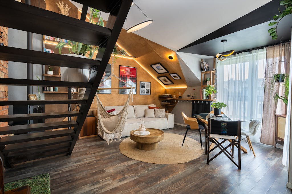 Stylish loft living room featuring a hammock, loft staircase, and modern decor with natural light.